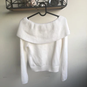 Vit offshoulder stickad tröja från zara - Superfin vit stickad tröja med bred ribbad offshoulder-krage. Tröjan har lång ärm och ribbade muddar vid ärmslut och nederkant. Den är storlek S men passar M oxå