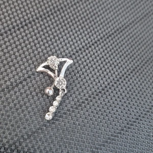 Floating navelpiercing  - Floating navelpiercingsmycke i silverfärg med glittrande stenar och hängande detaljer. Snygg design med bågform och flera infattade stenar som ger extra bling. Perfekt för dig som vill ha något som sticker ut och glänser. 316L kirurgiskt stål .