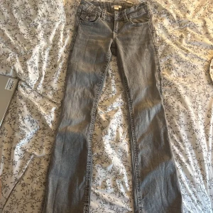 Grå jeans från Gina Tricot, bootcut - Säljer ett par grå jeans från Gina Tricot i storlek 152. Modellen har klassisk femficksdesign och bootcut-ben, vilket ger en snygg siluett. Jeansen är i mjukt denimtyg.