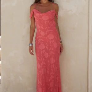 Rosa långklänning med blommönster - Snygg rosa långklänning med blommigt mönster och tunna axelband som går att reglera. Helt ny och oanvänd med prislapp kvar. Kommer från hemsidan: Runawaythelabel.com