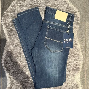 Sacré Slim Jeans Navy - Helt nya Sacré jeans, slim fit i mörkblå tvätt, storlek W33 (sitter som W32). Oanvända och med alla tags kvar – perfekt passform och snygg, tidlös tvätt.