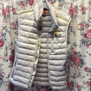 Vit dunväst från Parajumpers - Snygg vit dunväst från Parajumpers i storlek M. Västen har quiltad design, hög krage och dragkedja framtill samt två fickor med dragkedja. Perfekt för lager-på-lager och har en clean look med diskreta detaljer och logga i nacken.