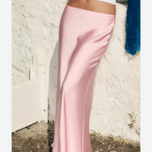 Ljusrosa kjol i satin - Supersnygg ljusrosa kjol i glansigt satinmaterial. Kjolen har en slät midja och faller elegant längs kroppen för en stilren och trendig look. Perfekt för dig som vill sticka ut med en feminin och chic vibe.