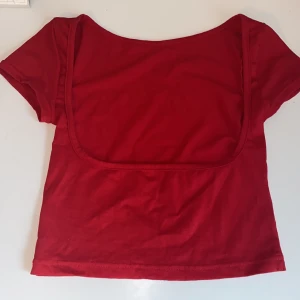 Open back röd topp - En röd croppad topp i bomull med korta ärmar och en snyggt öppen rygg. 