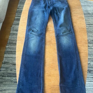 Mörkblå jeans från Denimbirds, 24/32 - Snygga mörkblå jeans från Denimbirds med snygg design på bakfickorna. Jeansen har raka ben och subtila slitningar för en cool look. 
