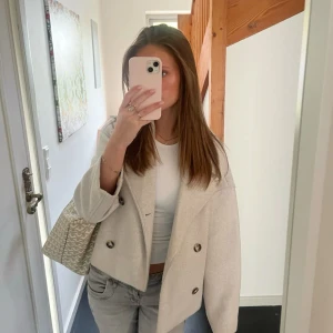 Beige kappa från Stradivarius  - Supersnygg beige croppad kappa från Stradivarius med dubbelknäppning och bred krage. Perfekt för dig som gillar stilrena och trendiga plagg med en oversized känsla. Fri frakt!🩷