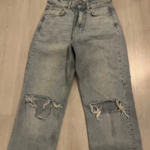 Ljusblå ripped jeans med raka ben - Säljer ett par ljusblå jeans med raka ben och slitna hål över knäna. Bra skick, jätte fina 