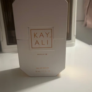 Kayali Vanilla | 28 Eau de Parfum 50ml - Kayali Vanilla | 28 Eau de Parfum i en lyxig, transparent glasflaska med guldiga detaljer och kristalliknande kork. Doften är varm och söt med tydlig vaniljton. Flaskan rymmer 50 ml och använd fåtal sprut!