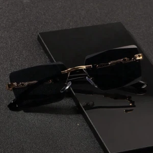 Svarta rektangulära solglasögon med gulddetaljer - Stilrena solglasögon med svarta glas och tunna skalmar i svart med lyxiga gulddetaljer. Glasögonen har minimalistisk design utan synlig ram runt glasen och coola detaljer vid gångjärnen. Perfekta för dig som vill sticka ut med en trendig accessoar. PRISET GÅR ATT DISKUTERA!