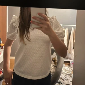 Vit blus med puffärm från JDY - Supersöt vit blus från JDY med korta puffärmar och diskret strukturmönster i tyget. Rund halsringning och lätt volangdetalj vid axlarna. Jättesnygg passar till allt! Använd en gång 