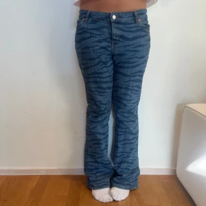 Blå jeans med zebramönster bootcut - Säljer ett par blå jeans med coolt zebramönster som är bootcut. Dom är i bra skick och modellen på bild är 171 cm lång. Hör av dig vid fler frågor och funderingar!