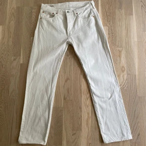 Vita Levi's 501 jeans W31 L30 - Säljer ett par klassiska vita Levi's 501 jeans i rak modell. Byxorna är i tjock bomull med fem fickor. Aldrig använda då de inte passade mig.                     Nypris: cirka 700 kr
