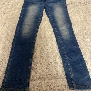Blå X-slim jeans från LAB Industries - Snygga blå jeans från LAB Industries i modellen X-slim. Jeansen har klassisk femficksdesign, slitningar och ljusa partier framtill och baktill för en cool look. Tillverkade i mer hållbar denim med kontrastsömmar och skinnpatch bak i midjan. Helt nya och fräscha nästan helt oanvända 