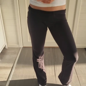 Svart yoga pants från Gina Tricot - Svarta yoga pants från Gina Tricot i mjukt och stretchigt material. De har låg midja och en skön passform som sitter snyggt över höfterna och släpper ut vid benen. Perfekta för en chill och trendig look.