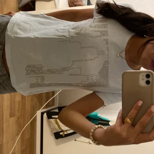 vit t-shirt - vit t-shirt med gråa små diamant detaljer, (diamanterna sitter fast bra så dom åker inte av i tvätt), vet dock tyvärr inte märket eftersom jag fick den av min farmor o står ingen lapp