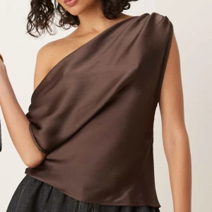 Brun ibiza top - Brun topp med ibiza stil som går att bära på olika sätt. Luftigt material och är aldrig använd, från asos🤎