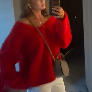 Röd stickad v-ringad tröja - Säljer en röd stickad tröja med v-ringning och lång ärm. Tröjan har en loose passform och är perfekt för dig som gillar en avslappnad och trendig stil. Den är mjuk och fluffig, vilket gör den extra mysig under kyliga dagar.den är från Hm edition därav mycket bättre kvalitet. Köptes för 800