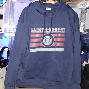 Saint Laurent hoodie  - Säljer min nuvarande Saint laurent hoddie då jag inte kan ha den nå mer. Den är L men skulle mer säga att den sitter som en M. Förhoppningsvis äkta, byte bort mina golden gosse men en snubbe inte 100% säker. Även öppen för byten helst nåt annan Saint laurent plagg, större storlek, eller nåt liknande :) inga skador som jag själv har lagt märke till!!! 