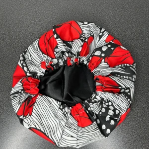 Satinbonnet med Afrikanskt mönster - Snygg satinbonnet med elastisk kant och coolt grafiskt mönster i rött, svart och vitt. Utsidan har stora röda former och vita linjer på svart botten, insidan är slät svart satin som skyddar håret. Perfekt för att hålla frisyren på plats under natten.