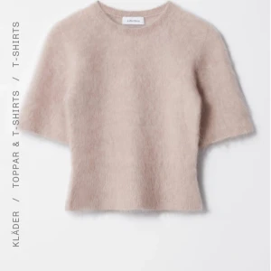 stickad topp från & Other Stories - Supermjuk och fluffig ljusrosa stickad topp från & Other Stories. Modellen har rund hals, korta ärmar och en rak passform. Perfekt för dig som gillar en mysig men stilren look.