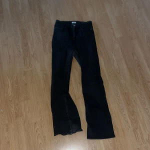 Svarta jeans från Lindex bootcut - Svarta jeans från Lindex med klassisk femficksdesign och bootcut-ben. Jeansen har normalhög midja och är tillverkade i ett mjukt bomullsmaterial med lite stretch. 
