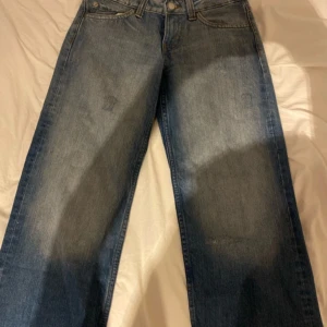 Wide jeans från Cheap Monday - Blå jeans från Cheap Monday med ikonisk dödskallepatch bak. Modellen har breda ben och klassisk femficksdesign. Jeansen är i denim med en snygg tvättad look och raka sömmar. Perfekta för dig som gillar en avslappnad och trendig stil.