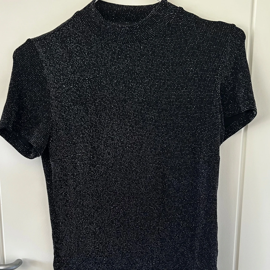 Glittrig svart topp från Monki