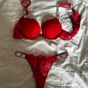 Röd spetsig set från Victoria's Secret - Rött glittrigt underklädes set från Victoria's Secret. ALDRIG ANVÄND och i toppskick med prislappen kvar. Mycket populärt set. Aldrig använd då den är för liten för mig. Underdelen i strl S och överdelen i strl 75A. 