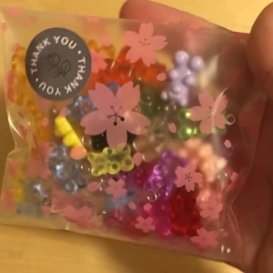 Mixade färgglada gummibjörns berlocker i plast - En söt påse med 60 st mixade berlocker i form av gummibjörnar i olika färger som rosa, blå, gul, lila, grön och röd. Perfekta att använda till att göra egna halsband, armband eller örhängen. Kommer i en förpackning med blommönster. Man kan köpa i mindre pack men då får man skriva till mig privat💞