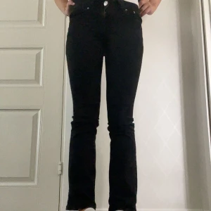 Svarta jeans från Gina Tricot - Säljer ett par lågmidjade svarta bootcut jeans från Gina med knappfickot bak, modell Perfect Jeans. Använda men i fint skick, säljer pågrund av att de är liiite för korta för mig som är 165 cm lång. Storlek 34. Hör av er vid frågor! 🩷