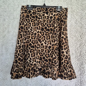 NA-KD XS / 34 leopard kjol - Super fin kjol från NA-KD i storlek XS (EU 34). Använd endast några få gånger och i mycket gott skick! Nytvättad i hygienprogram. Kjolen är tillverkad i 100 % polyester men känns tunn, mjuk och sval och är perfekt för sommar eller vår. Dragkedja i sidan. Sitter superfint på kroppen och ger en feminin siluett med volangkant nedtill. Obs se sista bilden där kan man se en pytteliten tråddragning som knappt syns vid användning upptäckte den först när jag tog bilden. Nypris 240kr  Skickar snabb💕