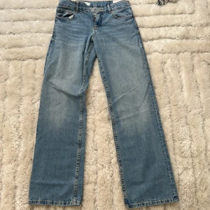 Wide leg low Rise jeans från Zara, ljusblå - Säljer ett par trendiga wide leg jeans från Zara i ljusblå tvätt. Jeansen har klassisk femficksdesign, raka och vida ben samt låg hmidja. Materialet är 100% bomull för en skön och avslappnad känsla. Perfekta för en chill och stilren look.