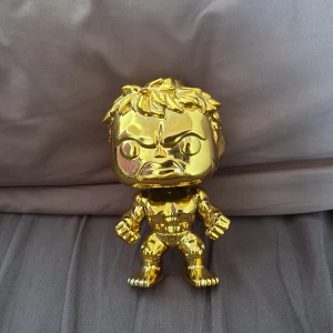Funko pop Hulken guldig  - Bilderna visar en gyllene samlarfigur med muskulös kropp och argt ansiktsuttryck.