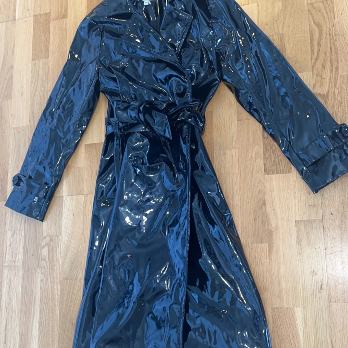 Svart glansig trenchcoat med knytning