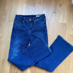 Blå jeans från Vero Moda - Snygga blå jeans från Vero Moda med klassisk femficksdesign och raka ben. Jeansen har normal passform och är tillverkade i ett mjukt denimtyg som passar perfekt till vardags. Stängs med dragkedja och knapp framtill.