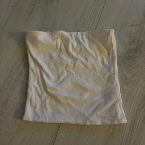 Vit tubtopp från BikBok - Säljer en enkel och stilren vit tubtopp från BikBok. Toppen är ärmlös och har en rak passform, perfekt att matcha med jeans eller kjol. Tillverkad i mjukt bomullsmaterial för en bekväm känsla.