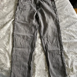 Grå jeans från Gina Tricot - Säljer ett par grå jeans från g perfect jeans i klassisk rak modell. Jeansen har fem fickor, normal passform och stängs med knapp och dragkedja. Perfekta till vardags och enkla att matcha med olika stilar. Passar dig som är ca 160cm lång.