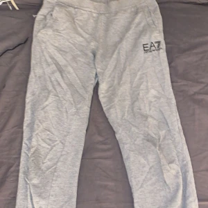Grå mjukisbyxor från Emporio Armani EA7 - PRIS KAN DISKUTERAS (Säljer ett par grå mjukisbyxor från Emporio Armani EA7. Byxorna har resår i midjan, sidofickor och en diskret EA7-logga på ena benet. Perfekta för en avslappnad stil och riktigt sköna att ha på sig. Storleken är 14A 160cm så passar perfekt för dig som är 155/160cm lång och skulle säga de är XS/S, dem är även lågmidjade 