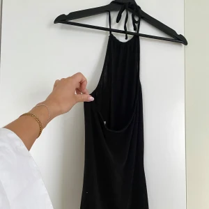 Klänning  - Helsvart klänning med halsknytning och öppen rygg🥰