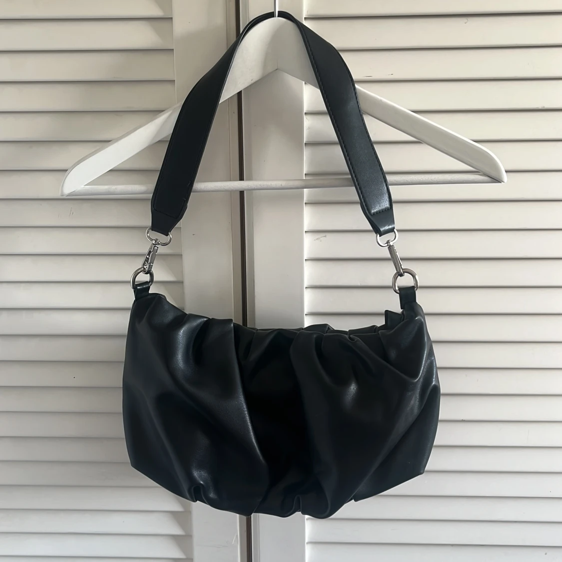 Svart axelväska i syntet