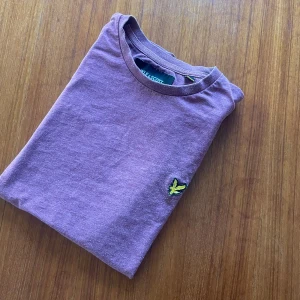 Vinröd Lyle scott T-shirt - Vinröd T-shirt från Lyle & Scott. Perfekt för en stilren outfit med elegans. Perfekt för en varm sommardag. Skicket är 8,5/10