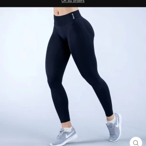 Svarta tights från DFNY - Säljer ett par svarta tights från DFNY med hög midja och tight passform. Perfekta för träning och har en stilren design utan synliga detaljer. Materialet är stretchigt och följsamt.