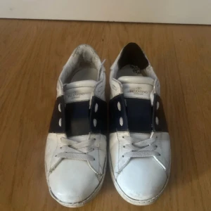 Valentino Open  - Säljer ett par vita Valentino Open sneakers. Dom är i ett använd skick med inga stora skador. Det är en grej för Hälen men syns ej vid användning. Hör av er vid frågor!!