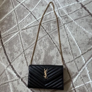 Svart axelväska  - Säljer en svart axelväska från Saint Laurent, såklart inte äkta men ser ut som de, inga defekter och knappt använd