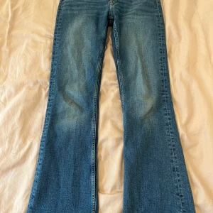 Blå bootcut jeans från Gina Tricot - Säljer ett par klassiska blå jeans från Gina Tricot young i bootcut-modell, storlek 158. De är i mycket fint skick men har en liten fläck/färgskiftning på baksida ben (se bild 4). Syns dock inte när man har jeansen på sig. De är justerbara i midjan med hjälp av resårband (se bild 5). De har lite slitningar vid kanten av fickorna, men det ingår i designen. Pris kan diskuteras! Tveka inte att kontakta vid frågor💕