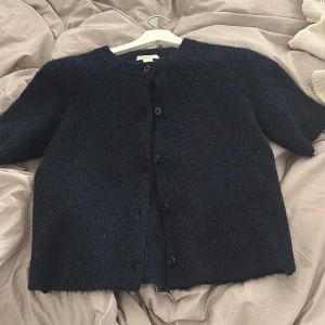 Svart stickad kofta från Gina Tricot - Fin kofta från Gina, den är stickad och från barnavdelningen men den är som en xs,s. Andvänd bara några få gånger 