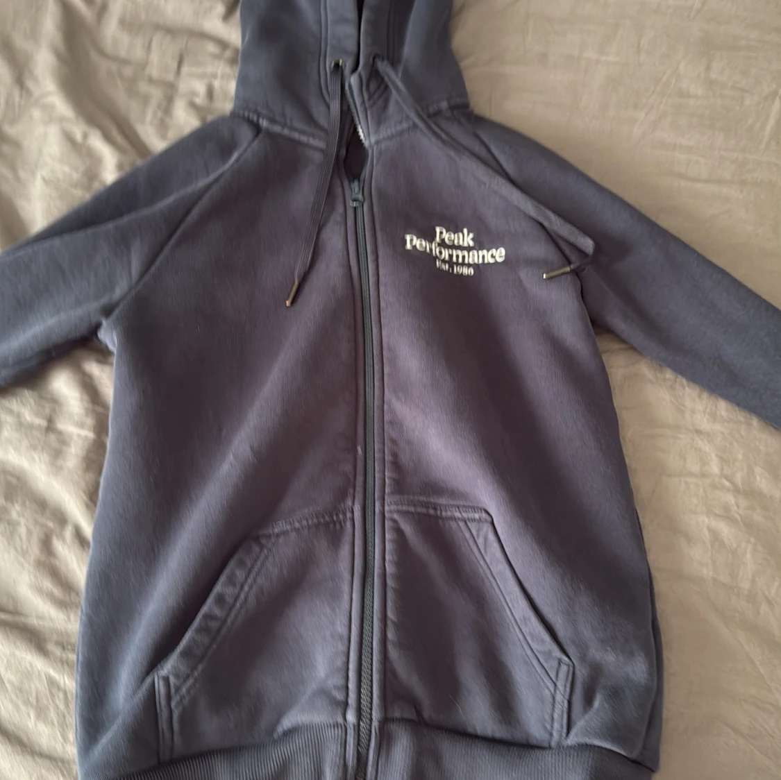 Mörkgrå hoodie med dragkedja från Peak Performance