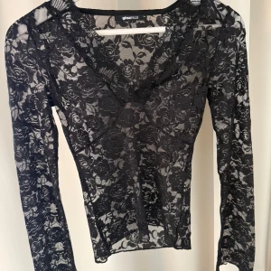Svart spetsblus från Gina Tricot - Säljer en svart långärmad spetsblus från Gina Tricot i storlek XS. Säljer då den inte kommer till användning. Sitter tajt
