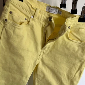 Gula jeans Other Stories - Gula jeans från Other Stories med klassisk femficksdesign och dragkedja. Byxorna har normal passform och raka ben.