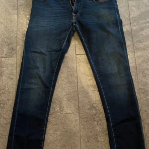 Mörkblå jeans från Jacob Cohën - Snygga mörkblå jeans från Jacob Cohën med   orange detaljer. Perfekta för dig som gillar stilrena och tidlösa jeans. Snygga för finare tillfällen men även till vardags 
